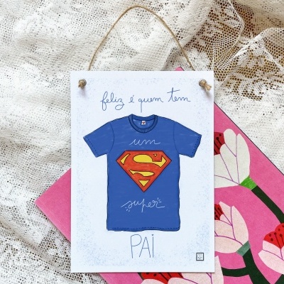 Placa decorativa com ilustração de t-shirt azul e texto feliz é quem tem um super PAI