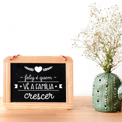 quadro decorativo em madeira com texto e vaso em forma de cacto com flores secas