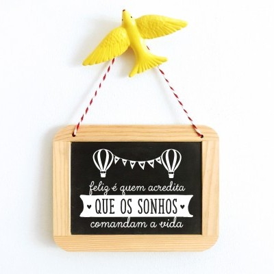 Placa decorativa em madeira com texto e pássaro amarelo pendurado