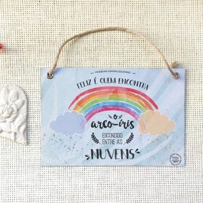 Placa decorativa com arco-íris e texto, e ornamento em formato de coração branco