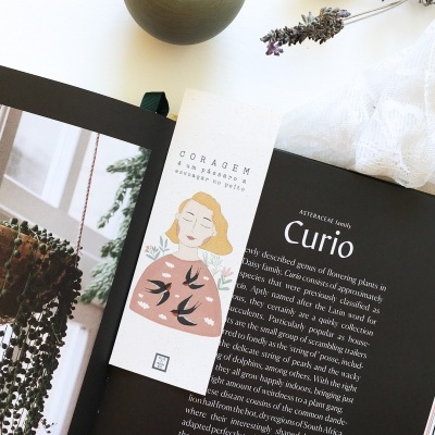 Marcador de livros ilustrado num livro aberto com texto e foto de planta