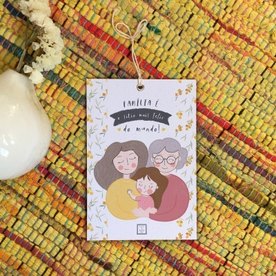 Etiqueta ilustrada com texto pendurada sobre tapete colorido e bola decorativa branca