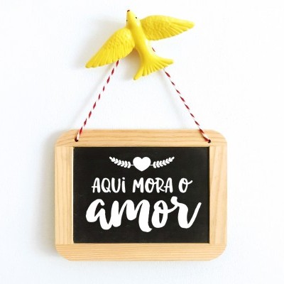 Placa decorativa em madeira com frase em português e pássaro amarelo