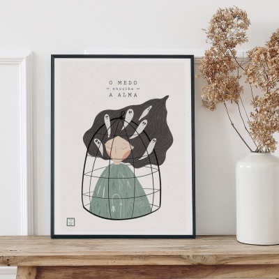 Quadro emoldurado com ilustração abstrata e frase em português, sobre uma bancada de madeira com jarra branca e ramos secos.
