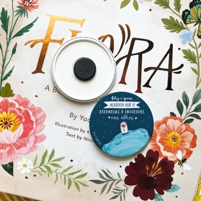 Livro com capa floral e dois frascos redondos de cosmético