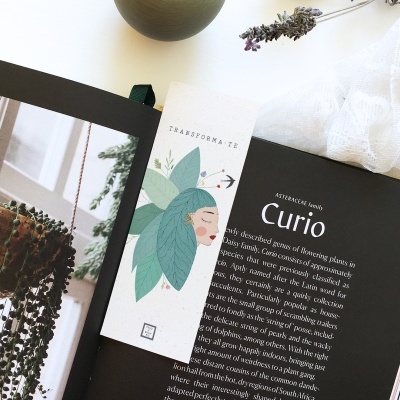 Marcador de livros ilustrado sobre livro aberto com texto em inglês e plantas