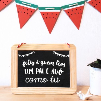 Quadro com texto sentimental em madeira e decoração de fatias de melancia e vaso branco com planta