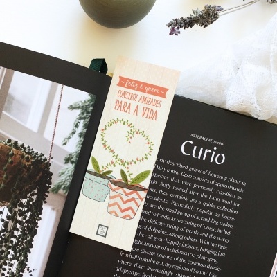 Marcador de livros com desenhos de vasos de plantas e texto em vermelho