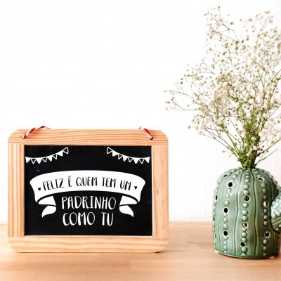 Caixa de madeira com quadro negro e vaso de cacto verde com flores brancas