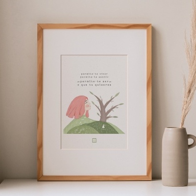 quadro em moldura de madeira com ilustração de coelho e texto, sobre uma superfície branca, ao lado de vaso com planta seca