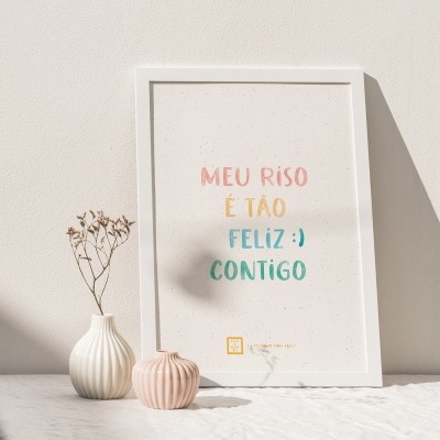 Quadro branco com texto colorido e dois pequenos vasos numa superfície branca