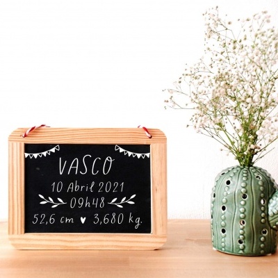 Quadro negro com texto branco e vaso verde em forma de cacto com flores