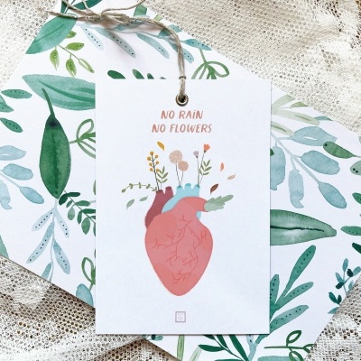 Cartão decorativo com coração e flores, texto 'NO RAIN NO FLOWERS' sobre papel de folhas verdes em fundo rendado branco