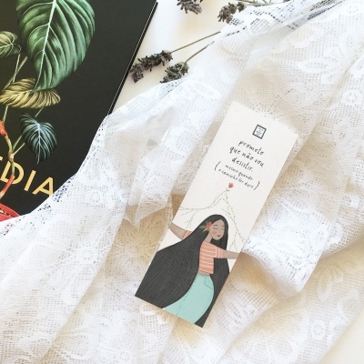 Cortina branca rendada, marcador de livro ilustrado e livro preto com folhas verdes