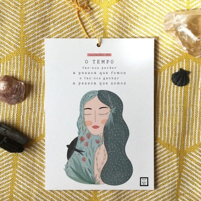 Cartão com ilustração de mulher e texto, rodeado por cristais sobre tecido amarelo
