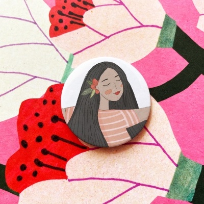 Botão redondo com ilustração de mulher e padrão floral colorido em fundo