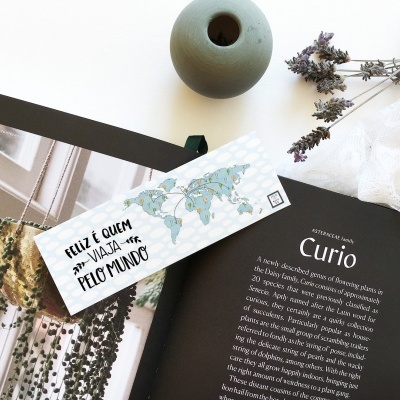 Marcador de página com mapa e texto em livro aberto com vaso e flores secas