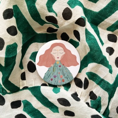 Lenço com padrão verde e preto e imagem circular de mulher ilustrada