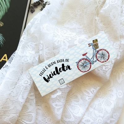 Etiqueta com ilustração de bicicleta e texto sobre tecido rendado branco
