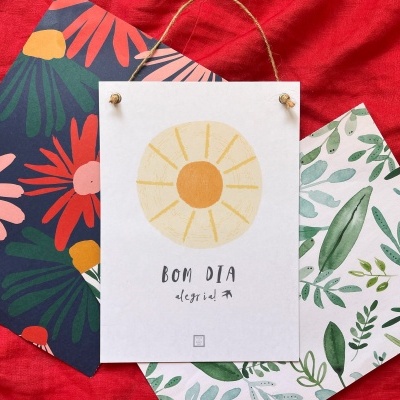 Três cartões decorativos coloridos com padrões florais e texto em português sobre fundo vermelho