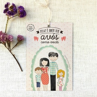 Cartão com ilustração de família e texto sobre avós, sobre tecido bege e flores secas