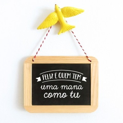 Placa decorativa com moldura de madeira, texto em lousa preta e pássaro amarelo pendurado.