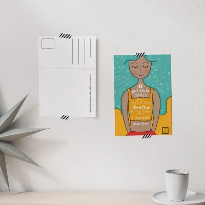 Dois postais na parede, estrela decorativa cinzenta e chávena branca sobre pires