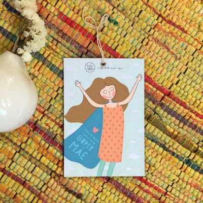Cartão ilustrado com figura feminina sobre tapete colorido e vaso branco com flor seca