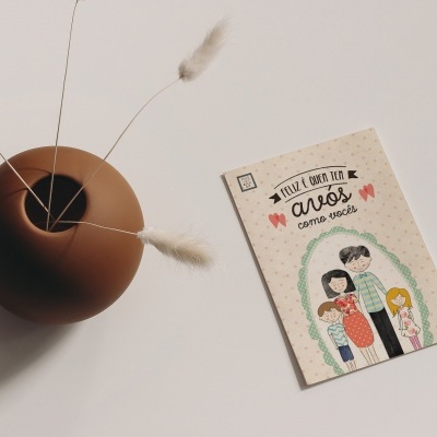 Cartão ilustrado com texto ao lado de vaso castanho com ramos secos.