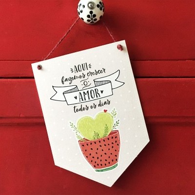 Placa decorativa com texto e ilustração pendurada numa porta vermelha