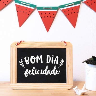 Quadro negro com texto e bandeirolas decorativas em forma de melancia