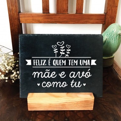 Placa decorativa preta com texto branco em base de madeira numa cadeira de madeira