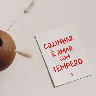 Cartaz com texto vermelho e vaso castanho com flores secas