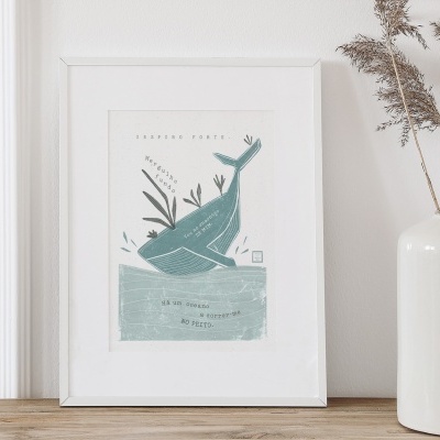 Quadro decorativo com desenho de baleia azul e texto, ao lado de vaso branco com folhas secas