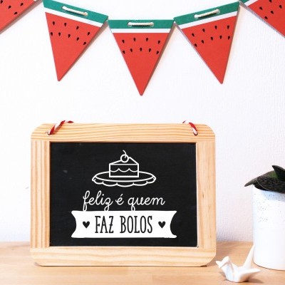 Painel de ardósia com texto em português e bandeirolas decorativas em formato de fatia de melancia