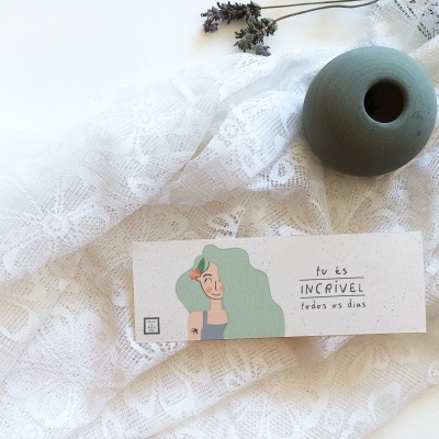 Cartão com ilustração e mensagem sobre tecido rendado e vaso cinzento