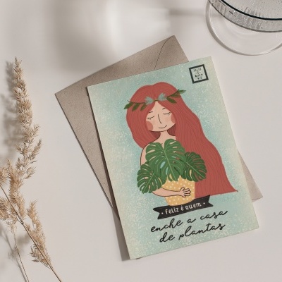 Cartão postal ilustrado com mulher e planta ao lado de envelope e rama seca