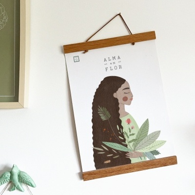Pôster ilustrado de mulher com folhas, pendurado numa moldura de madeira numa parede branca