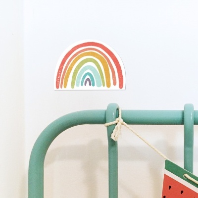 Cabeceira verde água com placa de melancia pendurada e autocolante arco-íris na parede