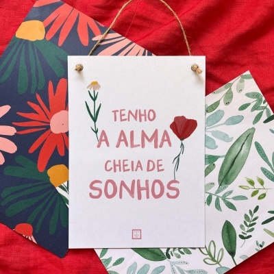 Três cartões com padrões florais e mensagem em português sobre tecido vermelho.