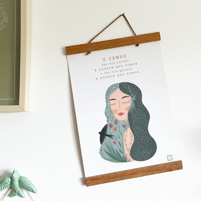 Póster com ilustração de mulher e texto em português pendurado numa parede branca