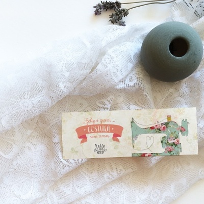 Caixa de sabonete artesanal colorida sobre tecido branco rendado com vaso cerâmico verde-acinzentado ao lado