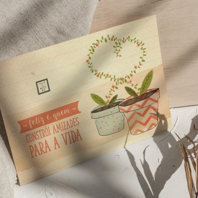 Cartão com ilustração de plantas e texto em português sobre tecido claro e sombra de planta seca