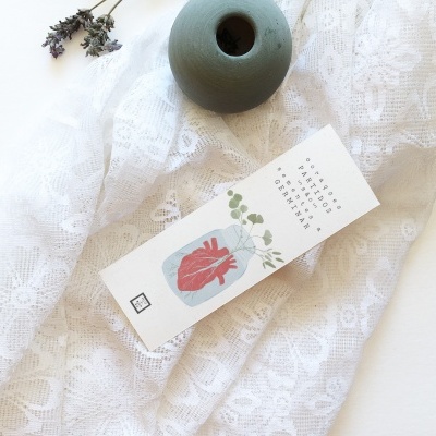 Caixa branca com ilustração de coração anatómico sobre tecido branco com vaso cerâmico