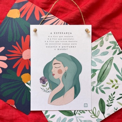 Placas decorativas com padrões florais e uma com ilustração de mulher e texto em português