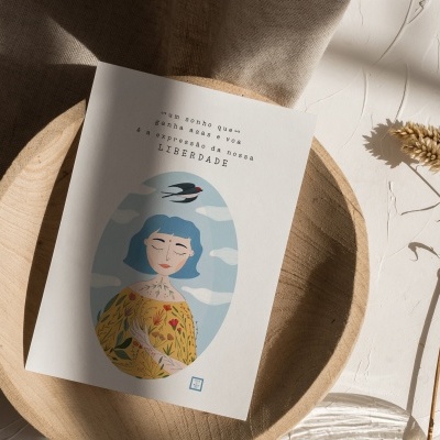 Cartão ilustrado com mulher de cabelo azul e texto em português sobre prato de madeira e tecido bege