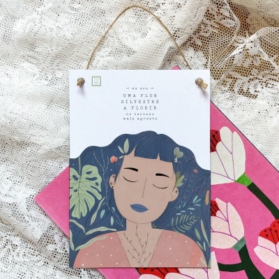Placa decorativa com ilustração de mulher e texto sobre fundo de renda branca
