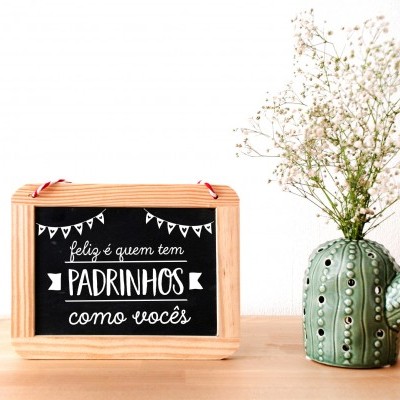 Caixa de madeira com texto em ardósia e vaso em forma de cacto verde com flores