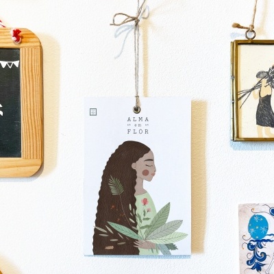 Quatro placas decorativas penduradas numa parede branca com diferentes ilustrações e texto.