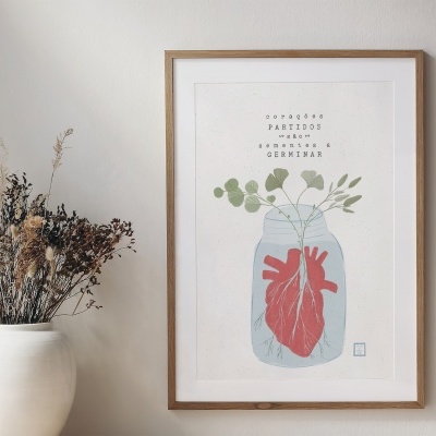 Quadro decorativo com ilustração de coração e texto, ao lado de vaso branco com flores secas.